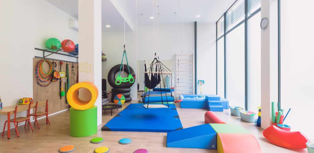 Sala de terapia ocupacional com integração sensorial, equipada para estimular o desenvolvimento motor, cognitivo e sensorial de crianças e jovens.